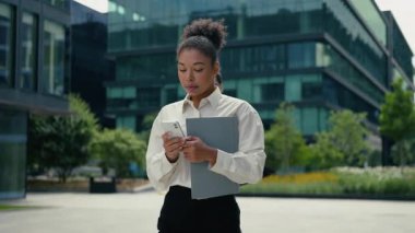 Çok ırklı iş ortakları, şehirde cep telefonuyla dolaşan Afrikalı iş kadınlarıyla buluşuyor. Kafkasyalı iş adamı, dışarıda gülen çeşitlilik arkadaşlığı hakkında konuşmak için koşuyor.