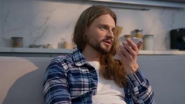 Evde konuşan mutlu beyaz adam akıllı telefon erkek ev sahibi adam hoparlör AI cep telefonu cihazı kullanıyor sesli mesaj kaydediyor. Müşterilere içeride teknolojinin tadını çıkar.