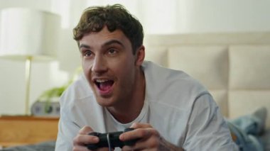 Mutlu Kafkasyalı genç adam evde yatıp video oyunu oynuyordu. Kumanda teknolojisi sanal sanal uzay eğlence odası tutarak oyun oynuyordu.