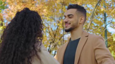 Sonbahar parkında buluşan İspanyol çift güz parkında konuşuyor gülümseyen Arap adam açık havada sevgili sevgili sevgili sevgili sevgili sevgili kız arkadaş ailesiyle buluşuyor.