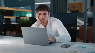 Sıkıcı, uykulu, yorgun, Kafkasyalı iş adamı dizüstü bilgisayara bakmaktan sıkılmış, motivasyonsuz, erkek, işçi işveren, bilgisayarla çalışan, akşam ofisinde can sıkıntısı çeken uykusuzluk çeken işvereni.