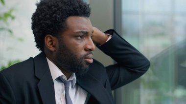 Gergin endişeleri kapat. Depresyondaki Afrikalı Amerikalı iş adamının sorunlu düşünme sorunu. Ofisin penceresine bakmak.