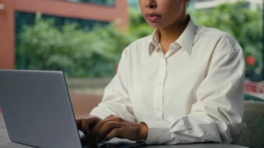 Afro-Amerikalı iş kadını hapşırırken dizüstü bilgisayar işkadını iş kadını hapşırma şehirdeki kafedeki ilaç alerjisi olan bayanın masasında internet yazılımıyla çalışıyor.