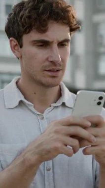 Üzgün, hayal kırıklığına uğramış Kafkasyalı iş adamı cep telefonundan kötü haberler okuyor stresli iş adamı işveren, akıllı telefon arızası arayan erkek işveren şehirdeki internet hizmetlerini kaybediyor