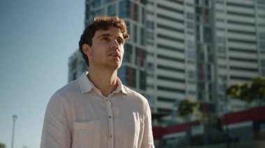 Güler yüzlü beyaz iş adamı şehre gidiyor binaların yakınına gökdelenler mutlu iş adamı gülümseyen işçi yatırımcı modern bölge yürüyüşüne bakıyor şehir merkezine gidiyor