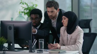 Ofisteki çok kültürlü iş arkadaşları çok ırklı üç iş arkadaşı birlikte çalışıyorlar. Çeşitlilik ortakları iş adamları bilgisayar toplantılarında beyin fırtınası çalışma sürecine işaret ediyorlar.