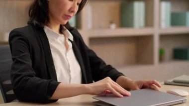 Mutlu orta yaşlı Asyalı gülümseyen iş kadını dizüstü bilgisayarı aç Koreli iş kadını yetişkin Japon kadın Çinli girişimci ile çalışmaya başla ofis bilgisayarında gülümse ve işine başla.