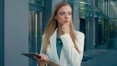 Düşünceli Kafkasyalı iş kadını dijital tablette yürüyor şehir dışında ciddi kadın iş kadını problem düşünüyor parmak çözümü fikri odaklı işçi öğrenci daktilo cihazı ekranı