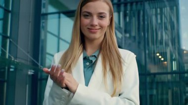 Kafkasyalı mutlu iş kadını el çırpıyor dışarıda ofis binasında el çırpıyor gülümsüyor kameraya bakan hırslı bayan iş kadını şirket çalışanlarını tebrik ediyor destek desteği veriyor.