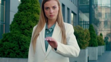 Katı beyaz iş kadını şehirde el hareketi yapıyor. Ciddi kadın iş kadını, HR müdürü. Hiçbir uyarıyı reddetmiyor.