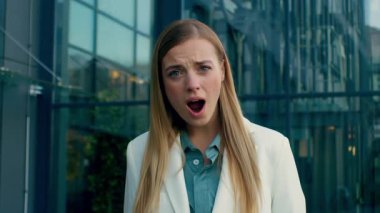 Şaşırmış Kafkasyalı iş kadını ofisin yakınında iyi haberleri görünce şok oldu. Kadın girişimci iş kadını şaşırdı. Başarı elde etti.
