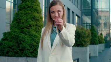 Mutlu gülümseyen beyaz iş kadını, hoş geldin demek için seni kameraya davet ediyorum. Şehir dışında mutlu bayan iş kadını yönetici. Kendine güvenen öğrenci kız el sallıyor.