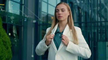 Başarılı bir Kafkasyalı iş kadını takım elbise ayarlıyor ofis binasında gururlu bir bayan iş kadını mülakat girişimcisi işe alıyor resmi ceketini düzeltiyor dışarıda yürüyor.