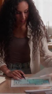 Düşünceli İspanyol iş kadını dizüstü bilgisayarda çalışıyor. İç dizayn fotoğraflarına bakıyor. Mutfak fotoğraflarına odaklanmış iş kadını.