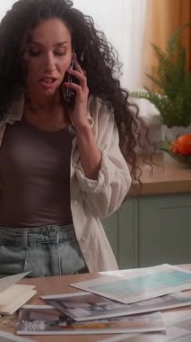 Sinirli Latin İspanyol tasarımcı kadın cep telefonu sorununu tartışıyordu ev sahibi kadın ev sahibi tartışması kavga eden kız iç tasarım mutfağı şablonu görünümlü.