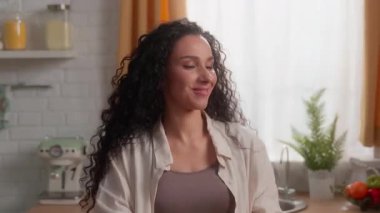 Mutlu, gülümseyen Latin bir kadın elma fırlatıyor kameraya bakıyor, göz kırpıyor sağlıklı yemek yiyor, ev hanımı besleniyor, eko vitamin yiyor, meyve vejetaryeni yakalıyor.