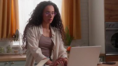 İspanyol Latin kadın baş ağrısı çekiyor. Mutfakta göz ağrısı çekiyor. Bilgisayarda çalışıyor. Uzaktan kumandalı iş kadını.