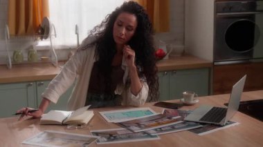 Konsantre olmuş İspanyol iş kadını iç dekorasyon fotoğraflarını seçiyor. Ev yapımı, ev yapımı, Latin kadın iş kadını. Daire örnekleri üzerinde kafa yoruyor.