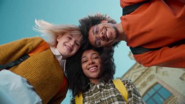 Kafa kafaya vermiş üç çok ırklı öğrenci, şehir üniversitesinde Afrika kökenli Amerikalı erkek, beyaz kadın kız kız kız kız, kız öğrenci jestlerinin başarısını kutluyor.