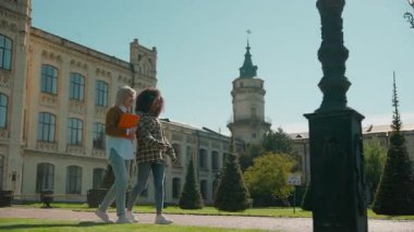 İki kız öğrenci açık hava akademisinde konuşuyor. Çok ırklı kadınlardan bahsediyorlar. Üniversiteye giden çok ırklı kadınlar.