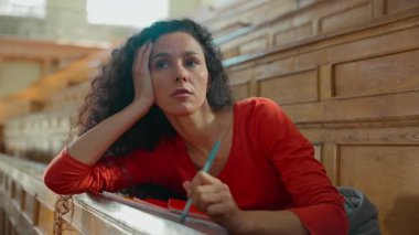 Düşünceli, İspanyol asıllı, Latin bir öğrenci, üniversite konferans salonunda oturup, tembel, düşünceli, düşünceli, üzgün bir kadın kadının, kitapların olduğu, üniversite akademisi derslerinde ders aldığını düşünüyor.