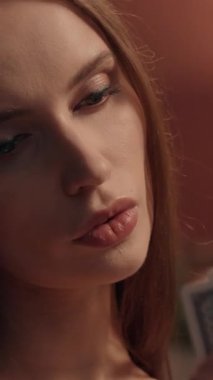 Poker kartları tutan zarif beyaz kadın evinde strateji kumarbazı odaklanmış genç bayan oyuncu kumarbaz kumarhane içinde kumarhane salonunda kumar oynuyor.