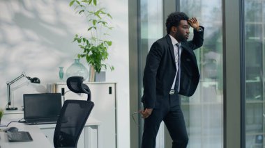 Dalgın Afrikalı Amerikalı iş adamı, kaygılarını dile getirdi. Pencereden bakıp çözüm arayışları kötü bir sorun yaratıyor. Etnik iş adamı çok çalışıyor.