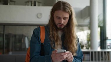 Gergin, stresli, beyaz bir adam cep telefonu hatasıyla kaybediyor, dolandırıcılık yapıyor, akıllı telefonlu erkek öğrenci üniversite akademisinde internet sorunu olduğu için asabını bozuyor.