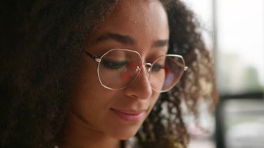 Kafası güzel, gülümseyen Afrikalı Amerikalı kız öğrenci kameraya bakıyor dişlek, dişçi, gözlüklü, etnik, neşeli kadın, üniversitede öğrenim görüyor.