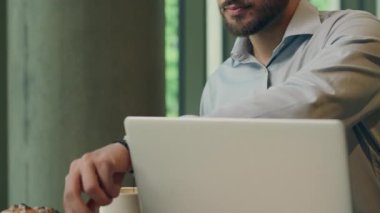 Etnik Hintli iş adamı konsantrasyonu projesi. Daktilo dizüstü bilgisayarını analiz et. Kahve fincanında şeker karıştır.