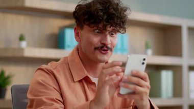 Kafkasyalı iş adamı cep telefonu uygulaması ile kazandı çevrimiçi oyun işadamı mutlu ofis çalışanı internet zaferiyle mutluluk hissetti siber alan kullanarak nakit para aldı