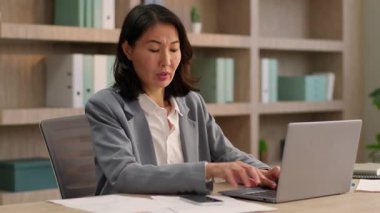 Orta yaşlı Asyalı iş kadını ofis masasında çoklu görev Çinli iş kadını cep telefonu araştırma belgelerine konuşan Koreli kadın Japon ajanla cevap veriyor.