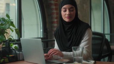 Müslüman İslami iş kadını tesettüre dizüstü bilgisayarda yazılım siber alanı internette su içme, su içme, su, denge, sağlık hizmetleri, ofis işkadını, iş kadını, iş kadını, kurumsal kadın.