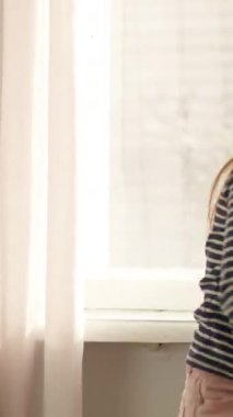 Mutlu Kafkasyalı küçük kız çocuğu çocuk dans ediyor. Evde dönüyor, gülümsüyor, dans ediyor, uzun saçlar uçuyor. İçeride eğleniyor.