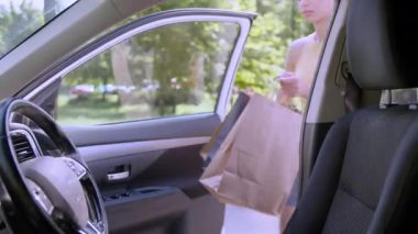 Yorgun, Afro-Amerikalı bir kadın elinde alışveriş çantalarıyla arabada oturuyor. Kadın sürücü, müşterinin içindeki alımlar yüzünden yorgun düşmüş, iş kadını nakliye paketleri alıyor.