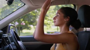 Güzel afro-amerikan iş kadını araba aynasında makyaj yapıyor kadın işkadını sürücü yansıma yüzünü kontrol ediyor otomobil taşımacılığında kozmetik kadın uyguluyor