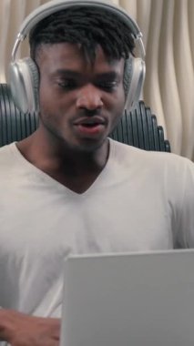 Beyaz fütürizm stüdyosundaki Afrikalı mutlu adam bilgisayarla kazanıyor. Fütüristik odada modern çevrimiçi yayın servisini izliyor. Kulaklık takan, bilgisayar bahsi oynayan bilgisayar korsanı adam hayrete düşüyor.