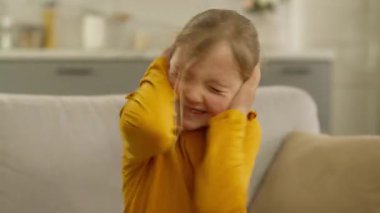 Kafkasyalı küçük kız çocuğu, kulaklarını tıkayarak başını sallıyor. Reddetme jestinde bulunmuyor. Evde gergin, sinirli, korkmuş, duygusal tepkisi olan, gürültü problemini dinlemeyi reddediyor.