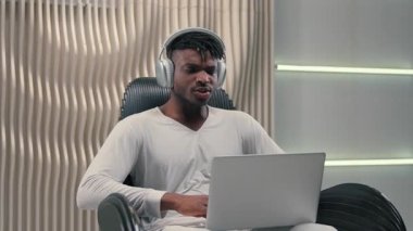 Kulaklıklı Afro-Amerikalı bir adam dizüstü bilgisayarla haykırıyor. Fütürist stüdyoda hayret verici bir şekilde heyecanlı bir erkek bilgisayar oyunu seyrediyor. Bilgisayarla zafer kazanan fütürizmin başarısını kutluyor.