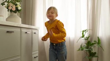 Neşeli beyaz kız çocuk neşeyle dans ediyor şarkı söylüyor zıplayarak eğlenceli çocuk kaygısızca eğleniyor haftasonunu kutluyor mutlu kız hareketli enerjik eğlence zamanı