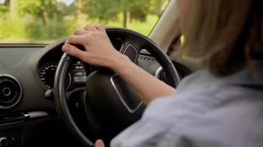 Yakından bakıldığında, tanımlanamayan Kafkasyalı yaşlı kadın, yaşlı, gri saçlı kadın, kadın, direksiyon tutan, direksiyonlu, direksiyonlu, otomobil direksiyonlu, aracın içinde dönen kadın elleri.