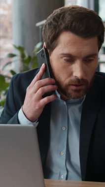 Ofiste cep telefonuyla konuşan Kafkasyalı işadamı, müşteri anlaşmazlığı hakkında konuşuyor. Kızgın erkek işadamı yönetici danışman, girişimci, kapalı alandaki stresli adama notlar yazıyor.