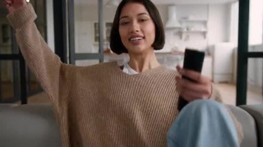 Mutlu İspanyol kadın evinde kanepede düşüp gülüyor televizyon kumandalı kız bayan ev sahibi kadın kanepe dinleniyor hafta sonları kanal değiştirip televizyon seyrediyor.