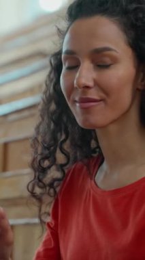 Üniversitede dizüstü bilgisayarda yazı yazan Latin kökenli kız. Kameraya gülümseyen, lisede internet işi yapan, internet üzerinden bilgisayar dersi alan bir kadın.