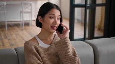 Gülümseyen İspanyol kadın gülerek cep telefonuyla konuşuyor. Haberleri tartışıyor. Kafkasyalı kadın ev sahibi kiracı kız.