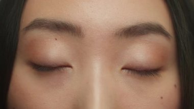 Asyalı etnik kadın siyah gözlerini kapat kameraya bak doğal güzellikte göz kırp Koreli Çinli kız görüş lazer düzeltici ilaç uzun kirpiklerini göz kırp