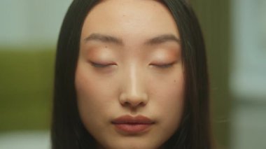 Güzel yüzlü, Asyalı, sevimli, gülümseyen Çinli, Koreli, etnik kız, Japon model, stüdyo içinde gülümseyen, sağlıklı, pürüzsüz, makyajlı, neşeli, neşeli, neşeli bir kadın.