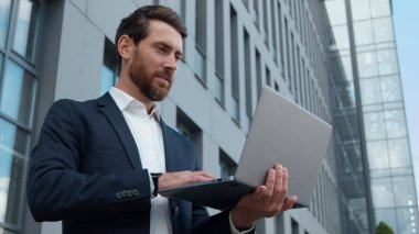 Ciddi odaklanmış Kafkasyalı olgun iş adamı dizüstü bilgisayarı olan iş adamı daktiloda erkek geliştirici bilgisayar geliştiriyor yazılım şirketi işini kullanarak sohbete başlıyor.