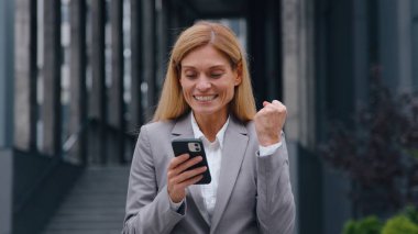 Şaşırtıcı mutlu Kafkasyalı 40 'lı yaşlarda iş kadını telefonda kazandı. Mobil uygulamayla kazanan iş kadını. Evet.