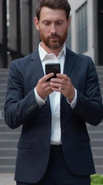 Şehirdeki başarılı iş adamlarından biri cep telefonuyla cep telefonu kullanıyor e-posta kontrolü yapıyor yetişkin erkek yöneticiler sosyal medyada sohbet ediyor. Yüksek